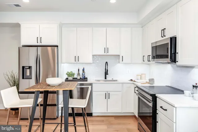 a kitchen with a table chairs refrigerator and microwave