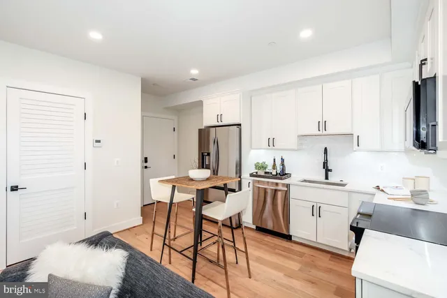 a kitchen with a dining table chairs and refrigerator