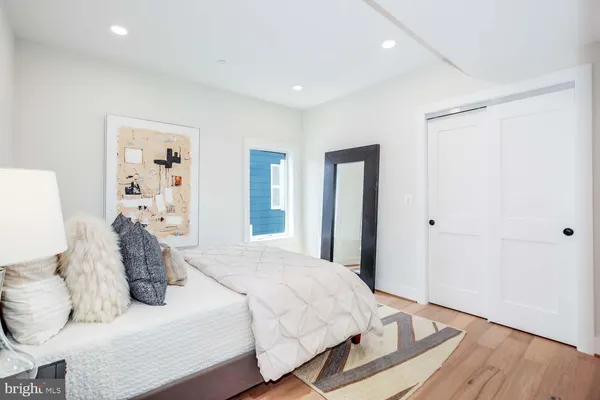 a bedroom with a large bed and wooden floor