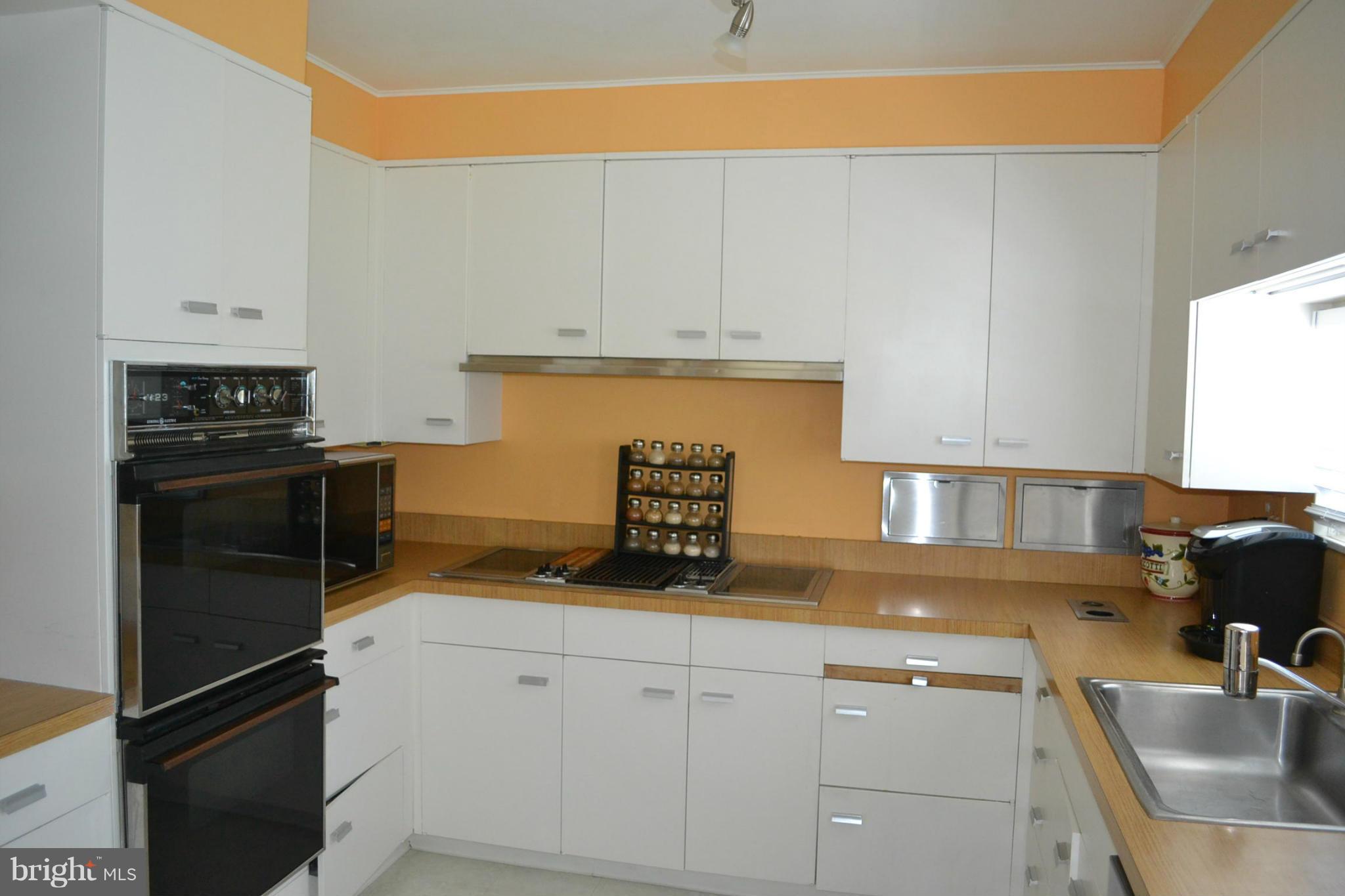 6602 Pimlico Road Baltimore, MD 21209 - Photo 14 of 23 a kitchen with white cabinets and stainless steel appliances