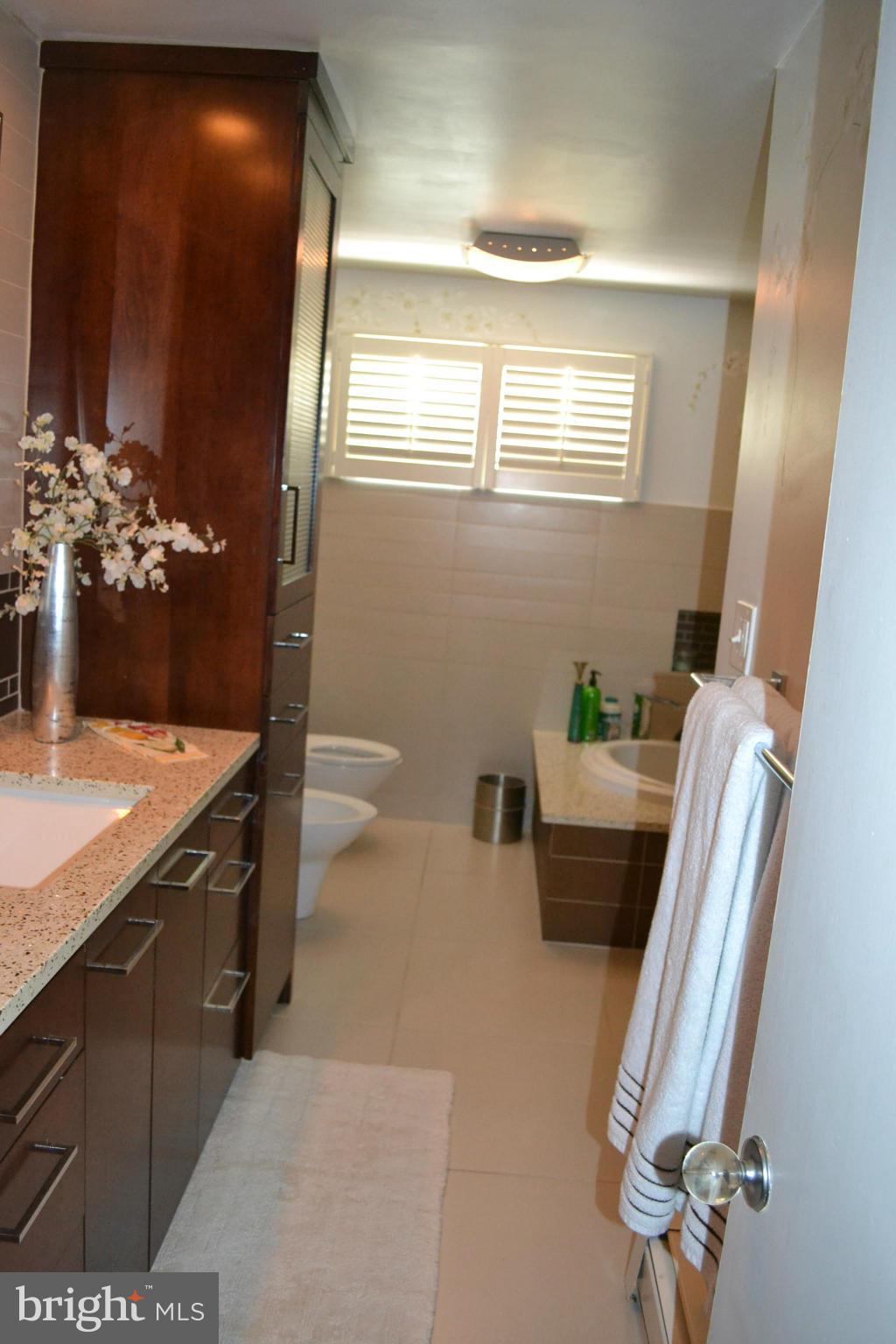 6602 Pimlico Road Baltimore, MD 21209 - Photo 7 of 23 a bathroom with a granite countertop sink a toilet and mirror