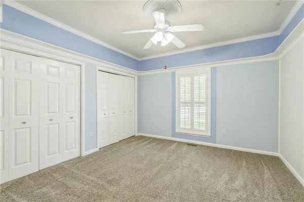 en empty room with windows and ceiling fan