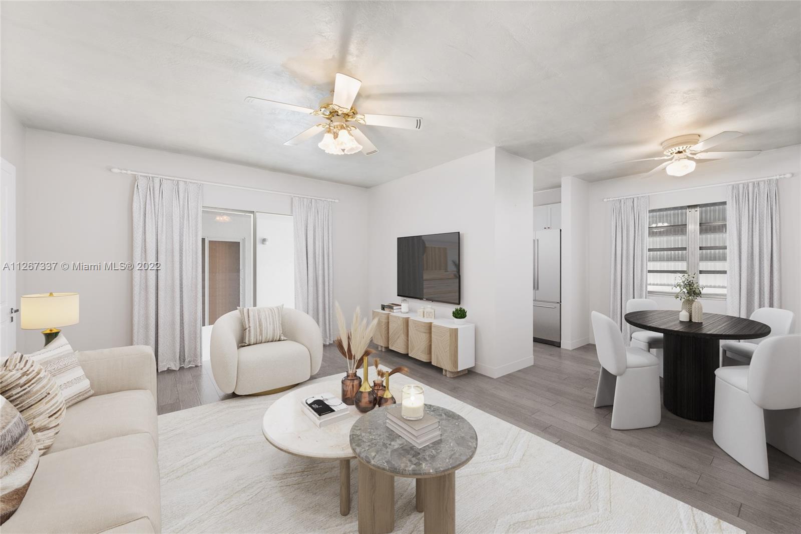 350 Collins Avenue, Unit 307 Miami Beach, FL 33139 - Photo 1 of 23 a living room with furniture a chandelier and a flat screen tv