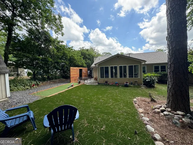 a view of a house with backyard and sitting area