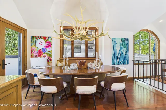 a view of a dining room with furniture a chandelier and wooden floor