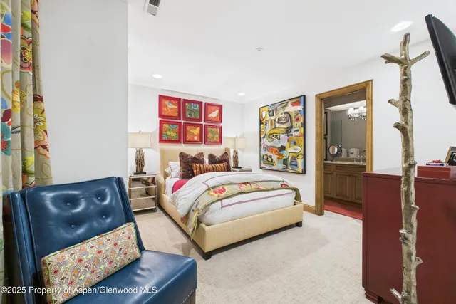 a bedroom with a bed window and a flat screen tv