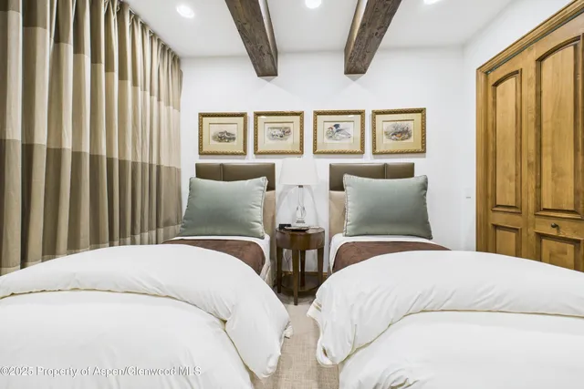 a bedroom with two beds and a painting on the wall