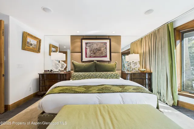 a bedroom with a bed and a painting on the wall