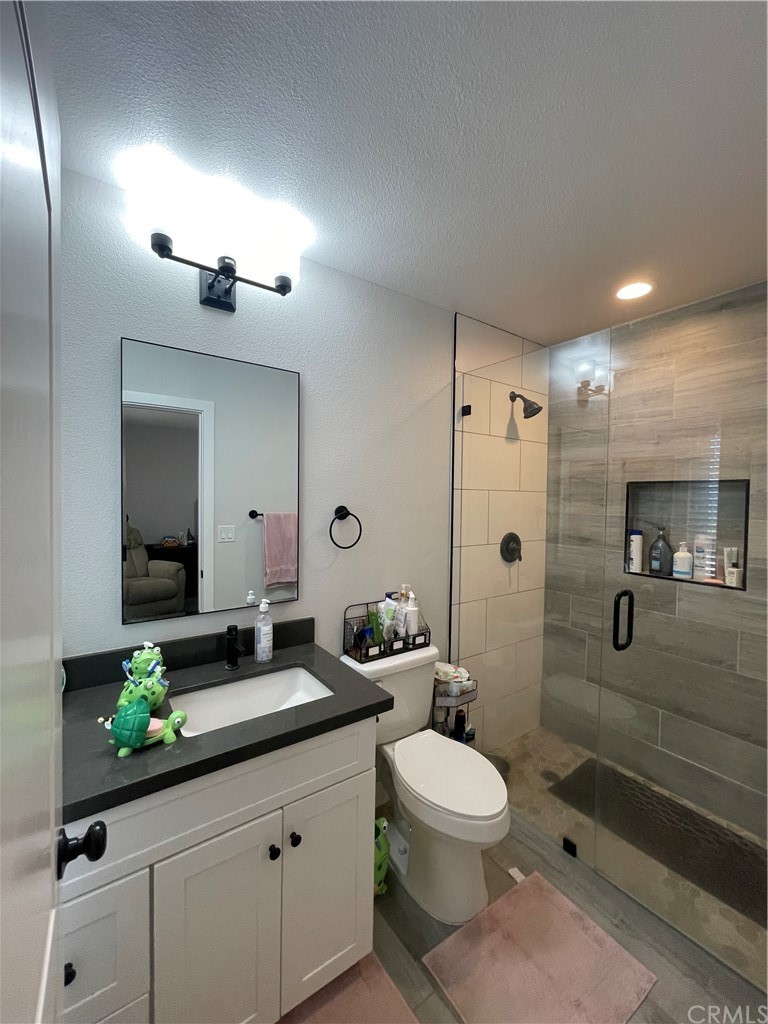 28950 Pebble Beach Drive Menifee, CA 92586 - Photo 12 of 18 a bathroom with a toilet a sink and mirror