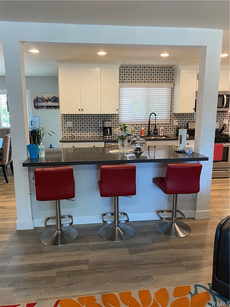 28950 Pebble Beach Drive Menifee, CA 92586 - Photo 6 of 18 a kitchen with cabinets and wooden floor