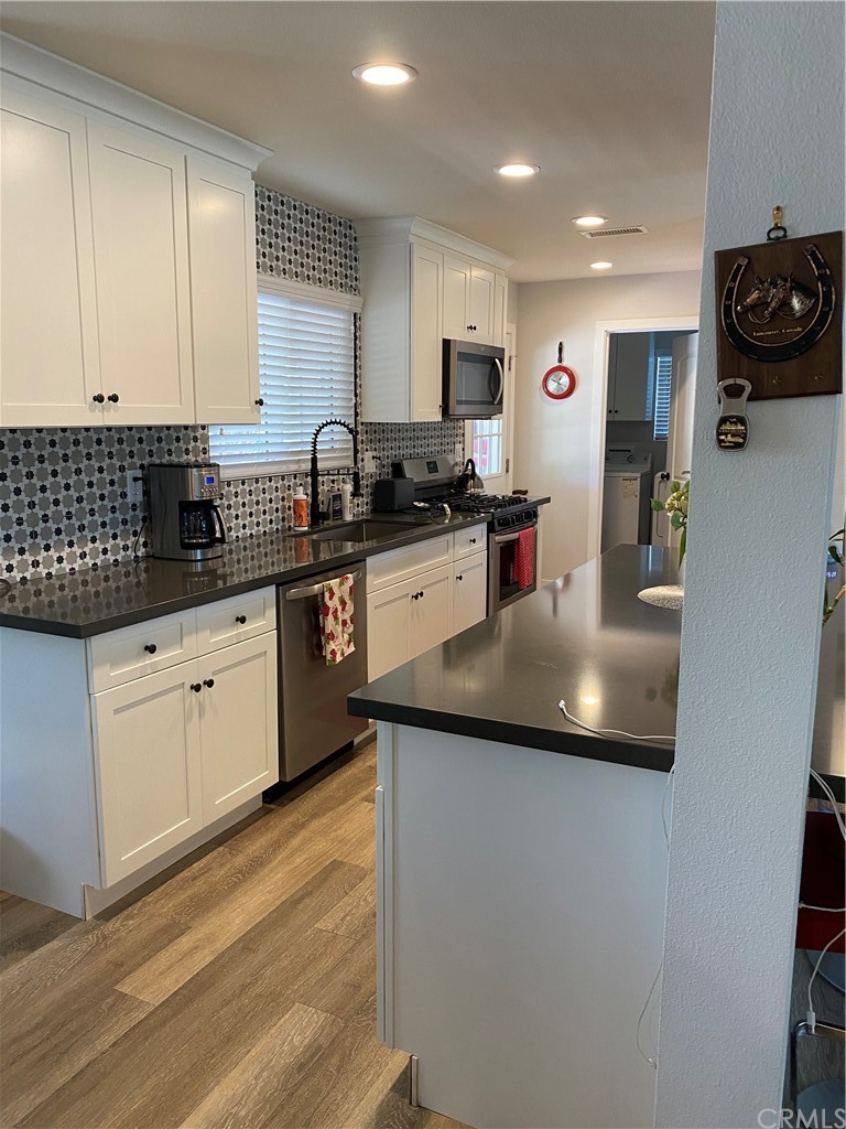 28950 Pebble Beach Drive Menifee, CA 92586 - Photo 7 of 18 a kitchen with stainless steel appliances granite countertop a sink a stove and cabinets