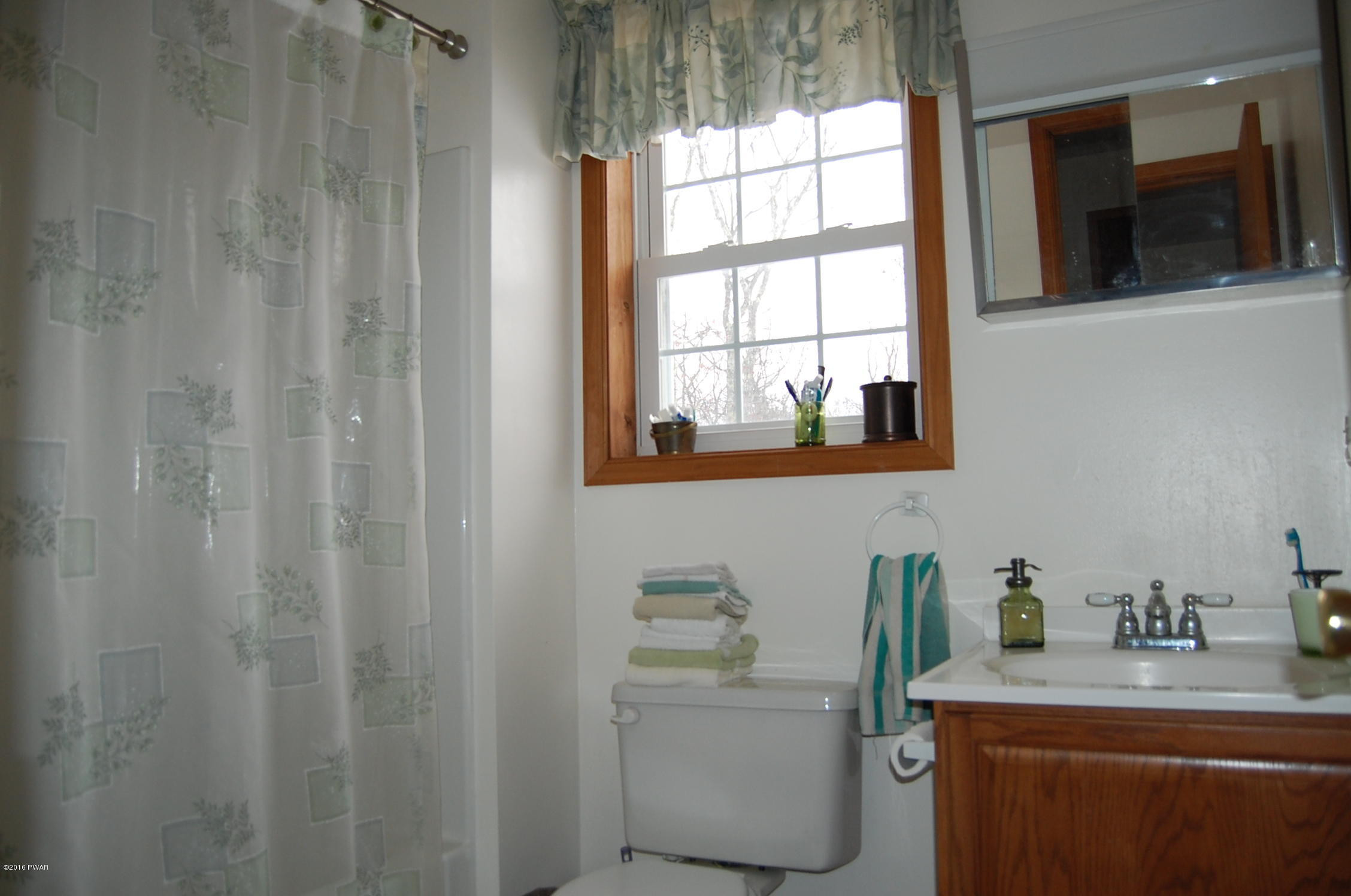 215 Maple Ridge Drive Hawley, PA 18428 - Photo 14 of 14 a room with a sink a mirror and a window