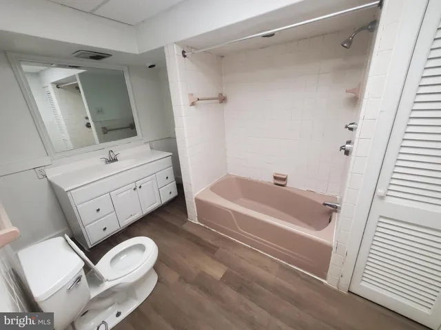 a bathroom with a sink mirror vanity and bathtub