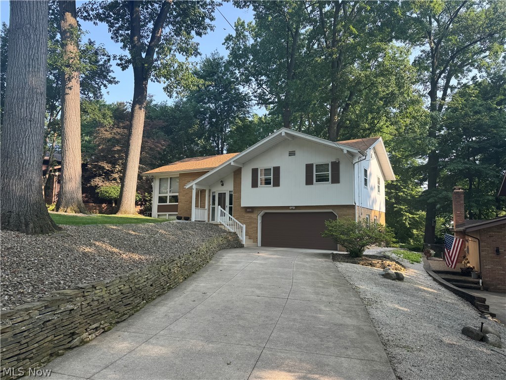 205 Rutledge Drive Akron, OH 44319 - Photo 2 of 8 Split-level residence featuring a two-car garage with a brown door, white siding, and a tan brick facade