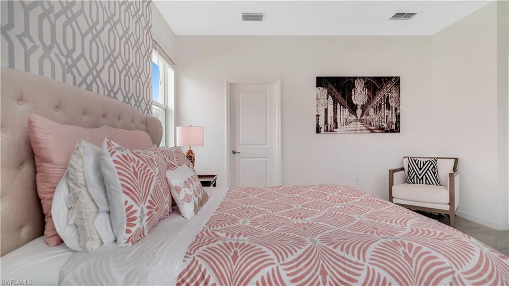 2425 Orchard Street Naples, FL 34120 - Photo 12 of 28 a bedroom with a bed and a painting on the wall