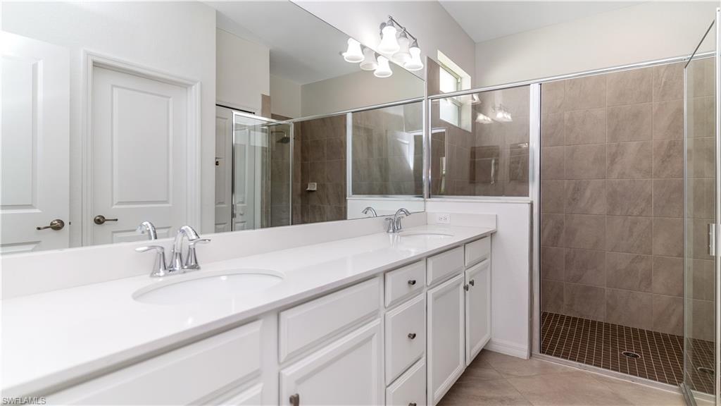2425 Orchard Street Naples, FL 34120 - Photo 13 of 28 a bathroom with a double vanity sink mirror and shower