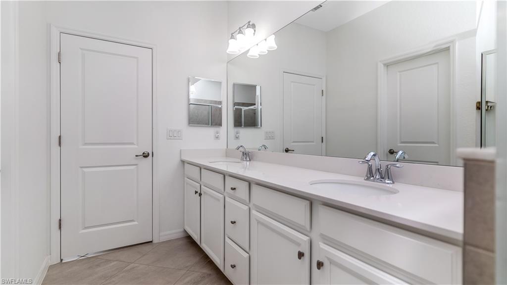 2425 Orchard Street Naples, FL 34120 - Photo 14 of 28 a bathroom with double vanity sink and a mirror