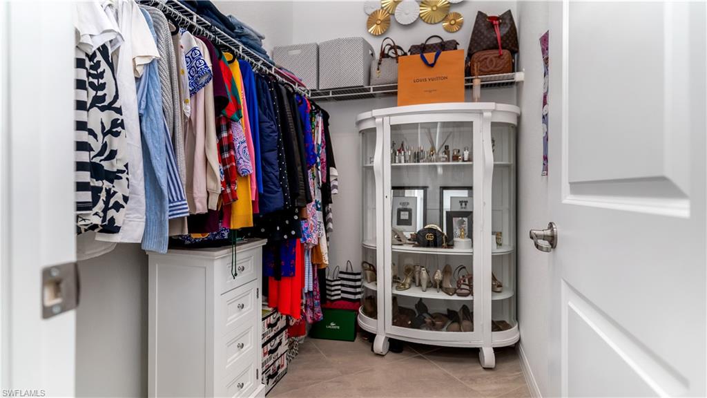 2425 Orchard Street Naples, FL 34120 - Photo 15 of 28 a view of walk in closet with clothes and shoes