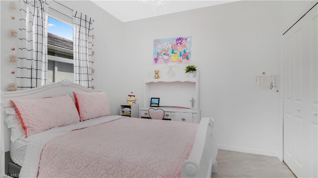 2425 Orchard Street Naples, FL 34120 - Photo 16 of 28 a bedroom with a bed and book shelf