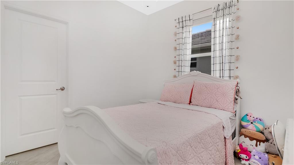 2425 Orchard Street Naples, FL 34120 - Photo 18 of 28 a bed sitting in a bedroom next to a window