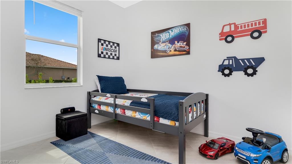 2425 Orchard Street Naples, FL 34120 - Photo 27 of 28 a bedroom with a bed and wall paintings