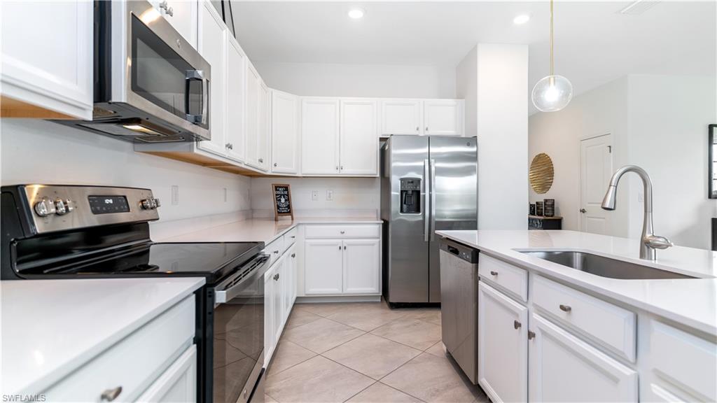 2425 Orchard Street Naples, FL 34120 - Photo 4 of 28 a kitchen with stainless steel appliances granite countertop a sink stove and refrigerator