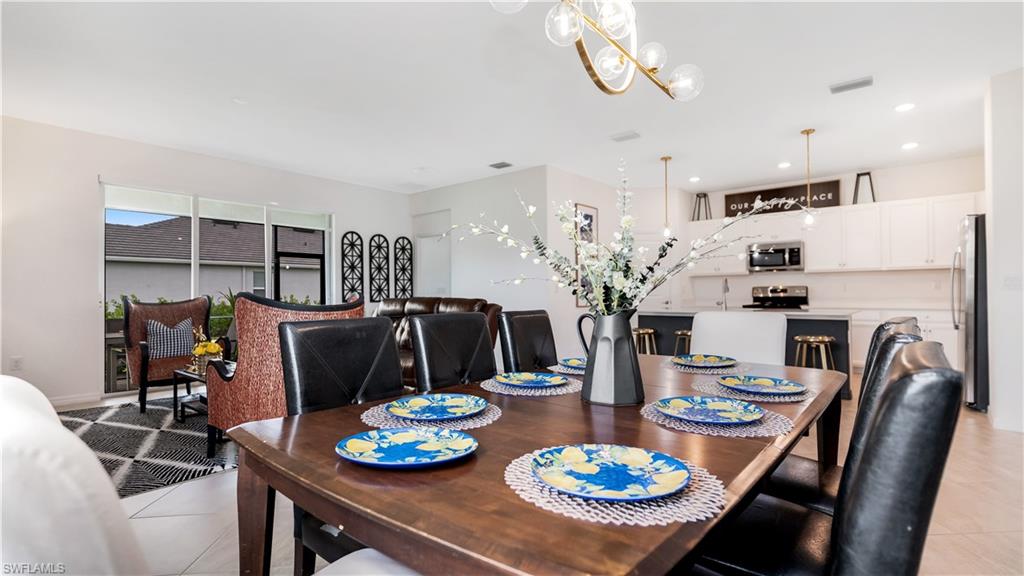 2425 Orchard Street Naples, FL 34120 - Photo 5 of 28 a view of a dining room with furniture a chandelier and wooden floor