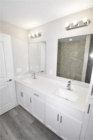 a bathroom with a double vanity sink and a mirror