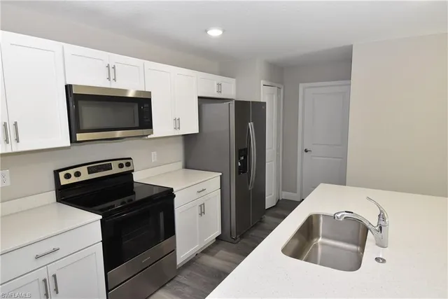 a kitchen with stainless steel appliances a stove microwave and refrigerator