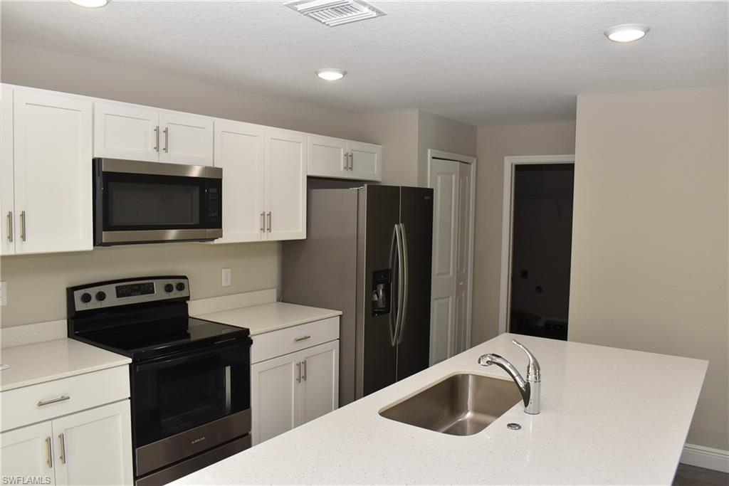 202 Seagrape Street Port Charlotte, FL 33954 - Photo 3 of 21 a kitchen with a sink a stove and refrigerator