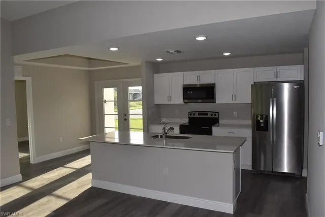 a kitchen with stainless steel appliances a refrigerator a sink a stove a microwave and cabinets