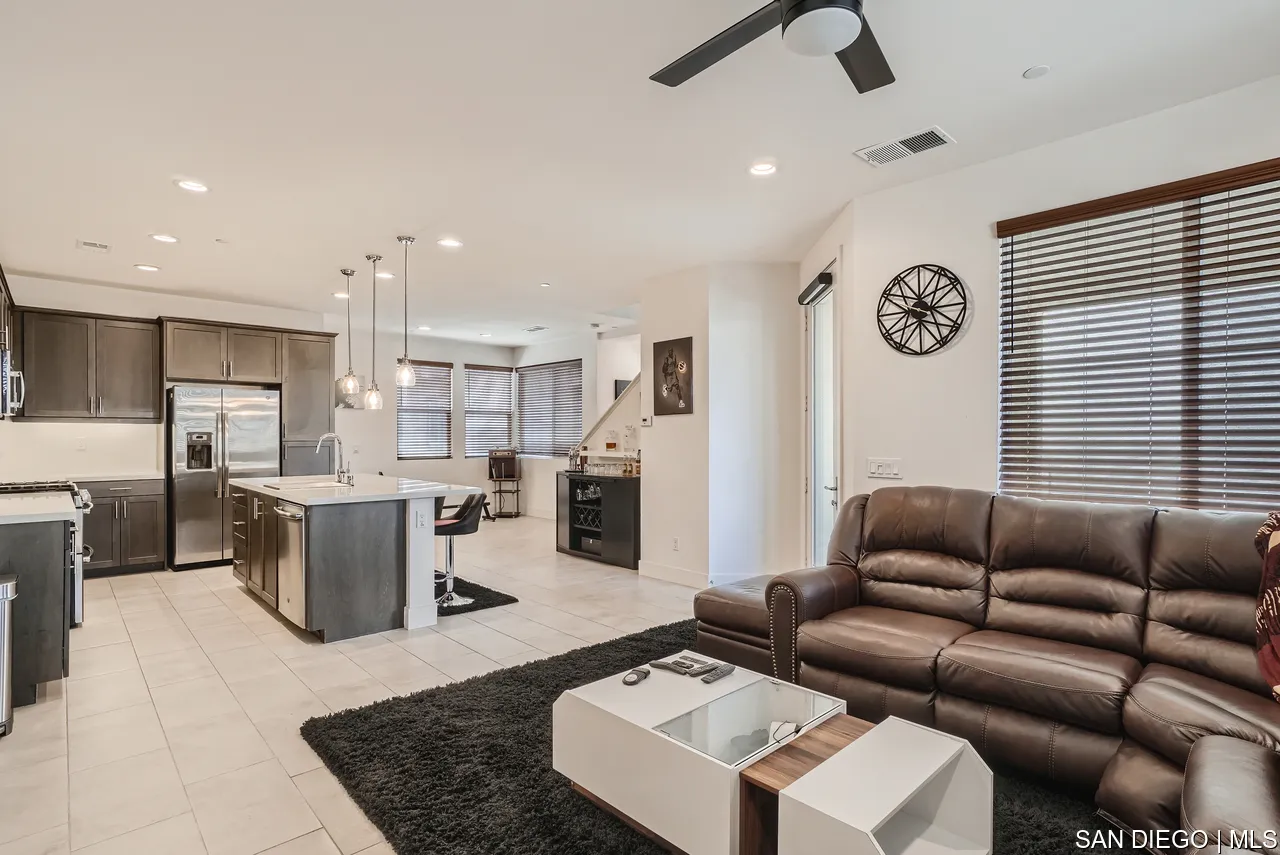 a living room with furniture kitchen view and a window