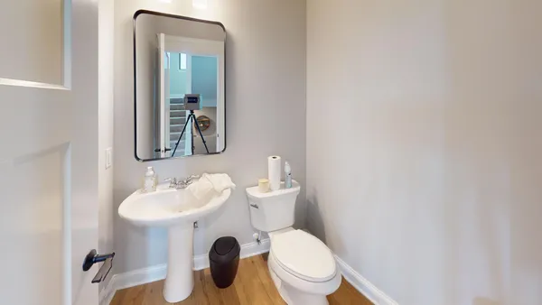 a bathroom with a toilet sink and mirror