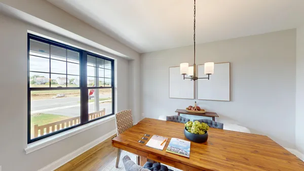 a view of a dining room with furniture a chandelier and wooden floor