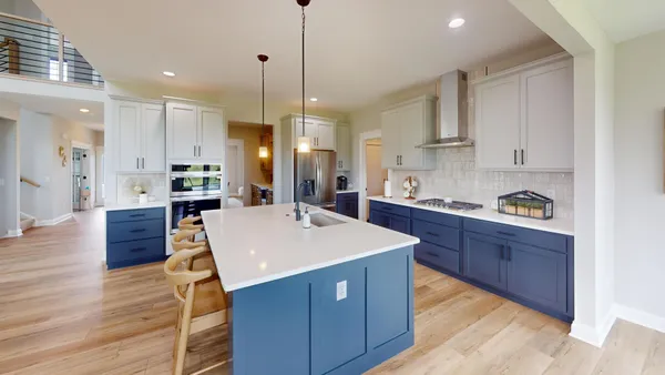 a large kitchen with stainless steel appliances a center island wooden floor and a sink