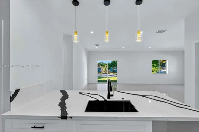 a kitchen with kitchen island a sink and a window