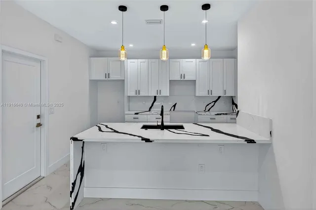 a kitchen with a sink a stove and cabinets
