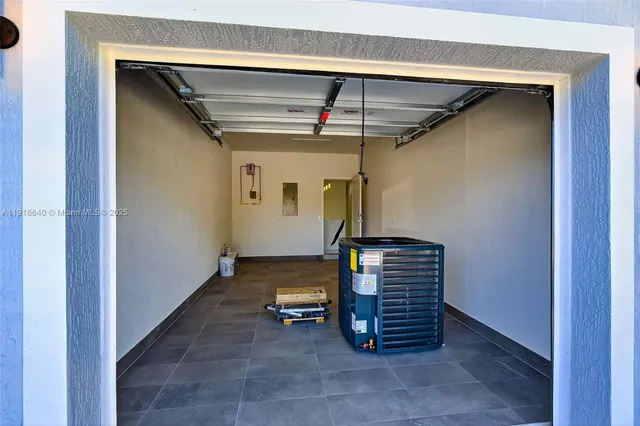 a view of a backyard with plants and large trees