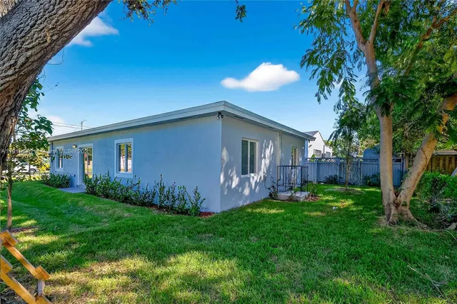 a front view of a house with a yard and potted plants