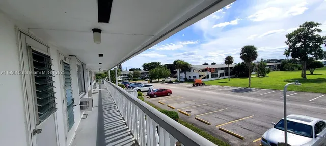 a view of a tennis ground with large trees