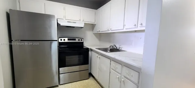 a kitchen with stainless steel appliances granite countertop a refrigerator and a stove