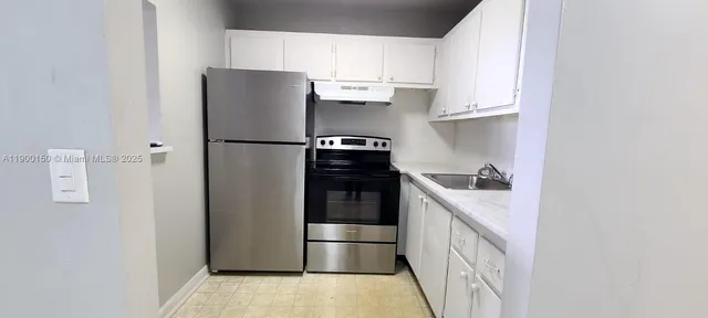 a kitchen with a refrigerator and a stove top oven
