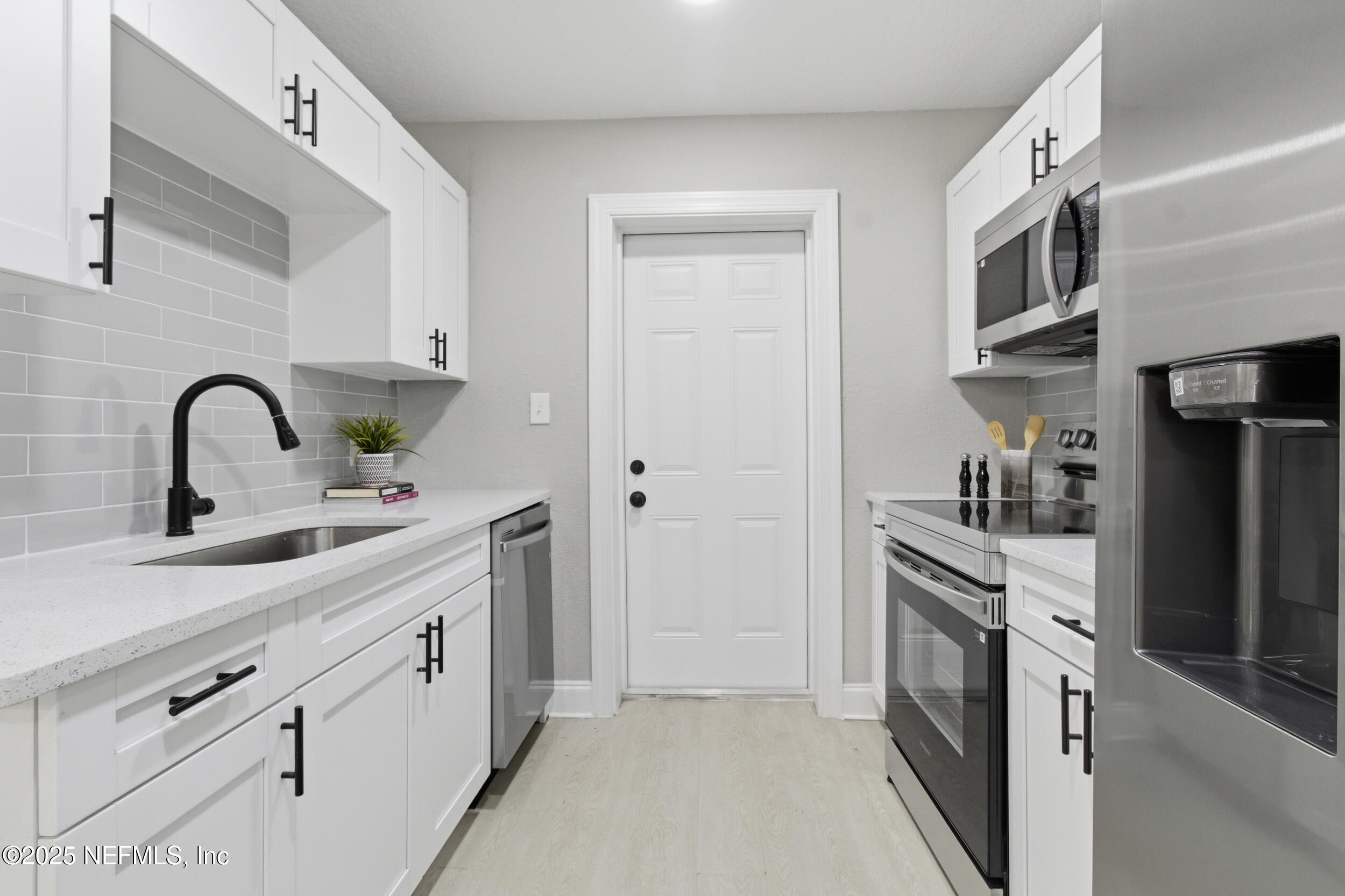5475 Gable Lane Jacksonville, FL 32211 - Photo 12 of 36 a kitchen with stainless steel appliances a sink cabinets and wooden floor
