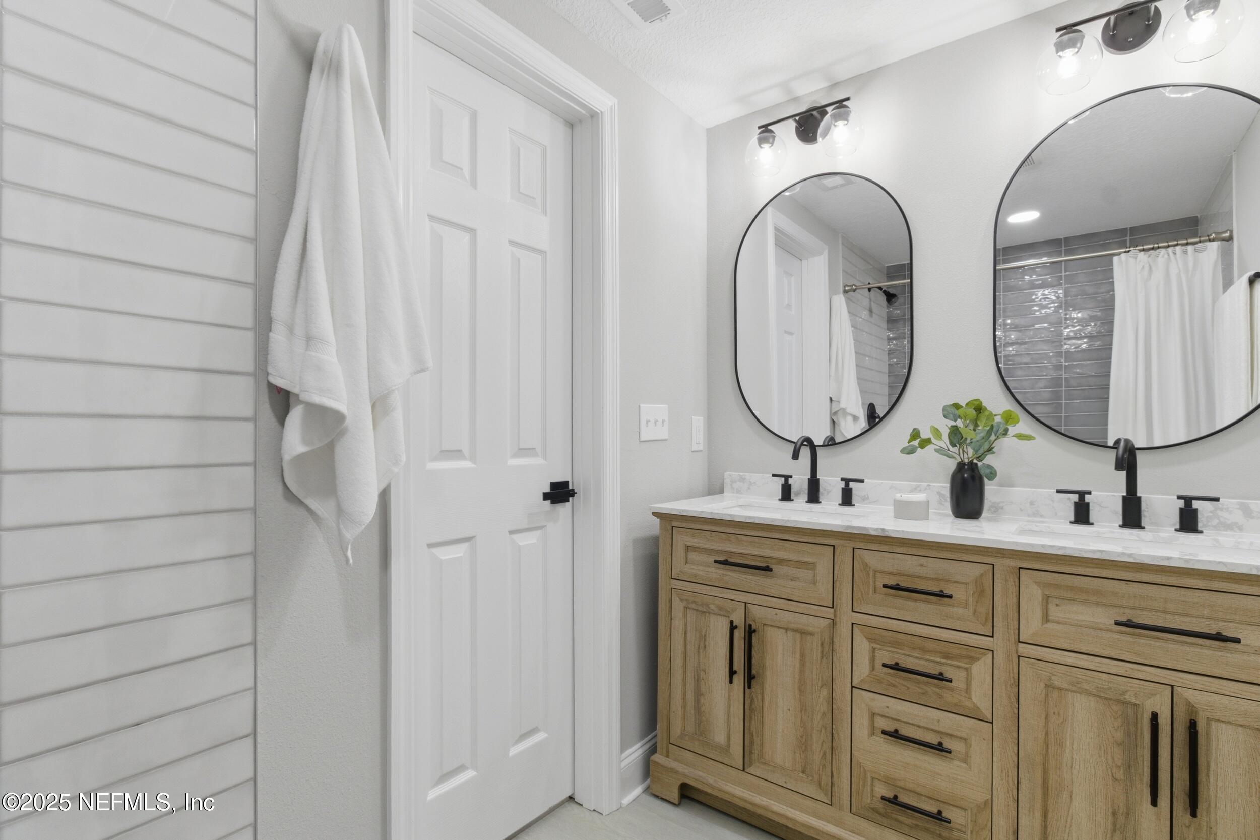 5475 Gable Lane Jacksonville, FL 32211 - Photo 17 of 36 a bathroom with a double vanity sink and a mirror