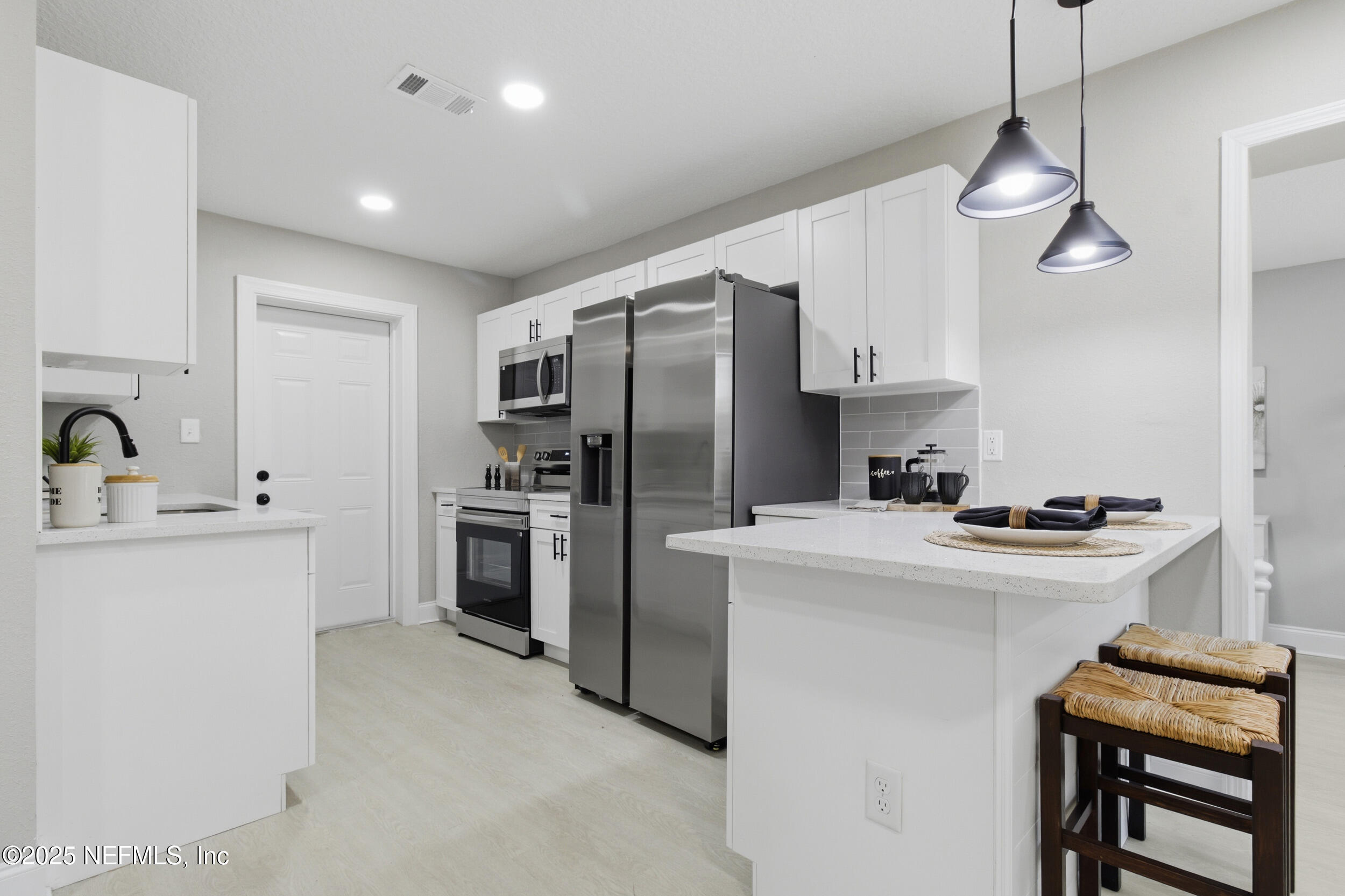5475 Gable Lane Jacksonville, FL 32211 - Photo 7 of 36 a kitchen with kitchen island a stove a sink and a refrigerator