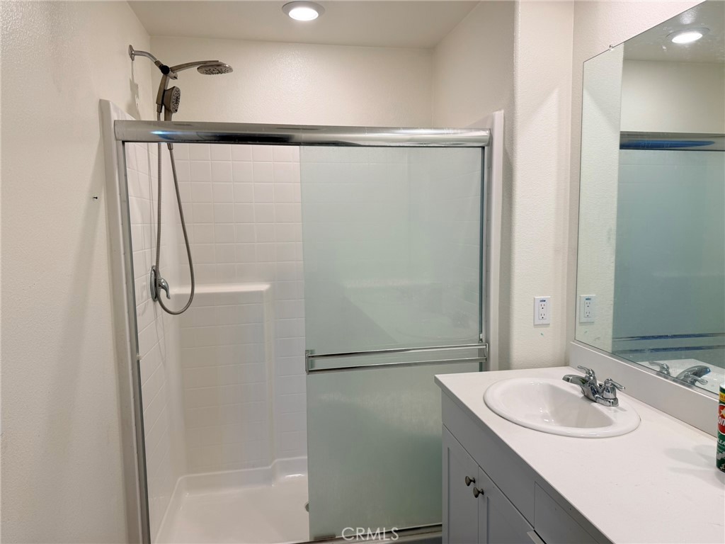 32201 Rambling Court Winchester, CA 92596 - Photo 7 of 11 a bathroom with a shower sink vanity and mirror