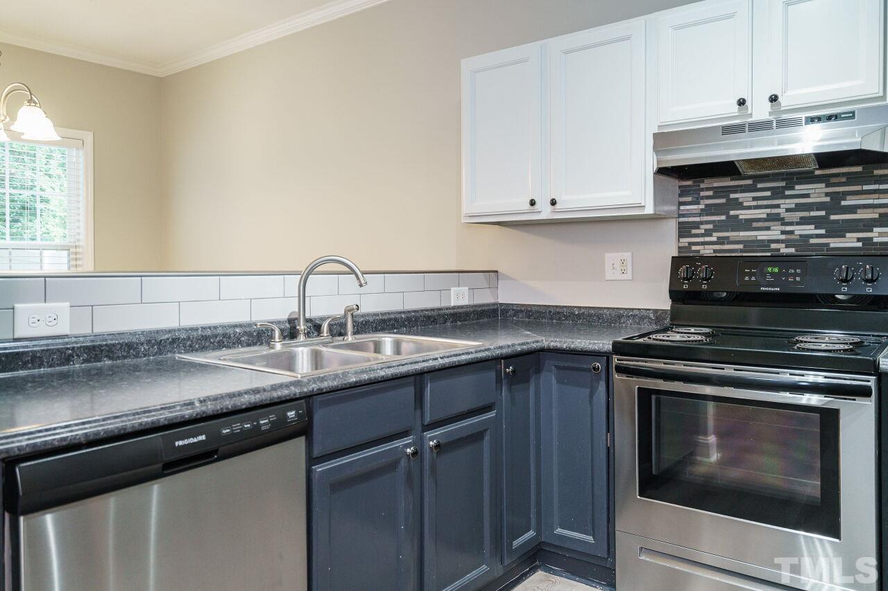 4509 Pinckney Place Raleigh, NC 27604 - Photo 12 of 28 a kitchen with stainless steel appliances granite countertop a sink stove and cabinets