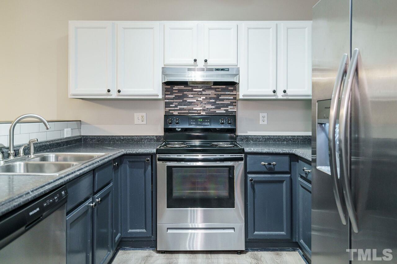 4509 Pinckney Place Raleigh, NC 27604 - Photo 13 of 28 a kitchen with granite countertop a stove sink and refrigerator