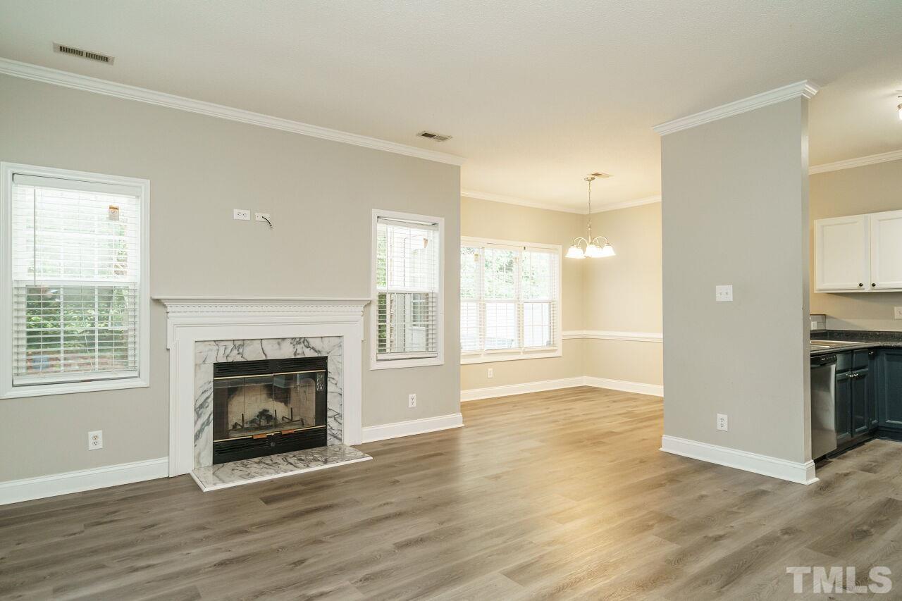 4509 Pinckney Place Raleigh, NC 27604 - Photo 7 of 28 an empty room with wooden floor fireplace and windows