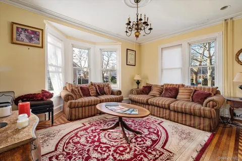 a living room with furniture windows and a chandelier